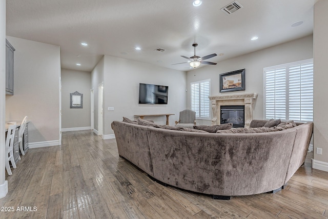 living room featuring wood-type flooring and ceiling fan