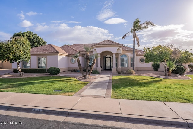 mediterranean / spanish-style home featuring a front yard