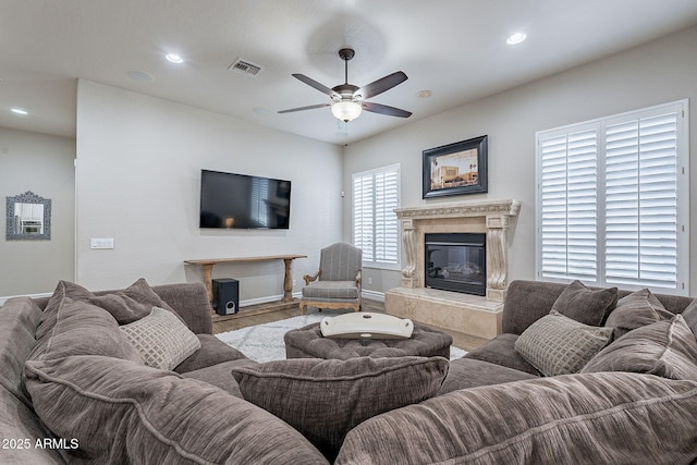 living room with ceiling fan, light wood-type flooring, and a premium fireplace