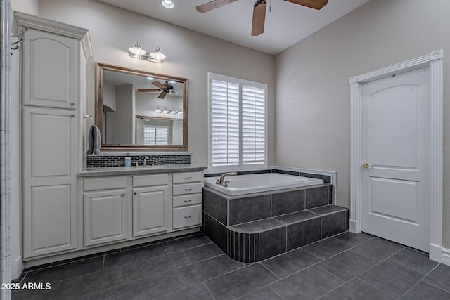 bathroom featuring decorative backsplash, vanity, tile patterned floors, and tiled tub