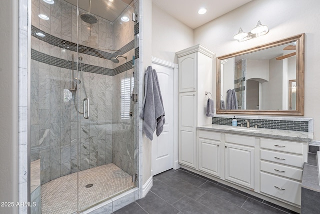 bathroom with tile patterned flooring, decorative backsplash, walk in shower, and vanity