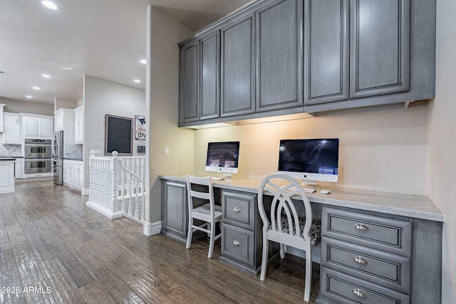 office space with dark hardwood / wood-style flooring and built in desk