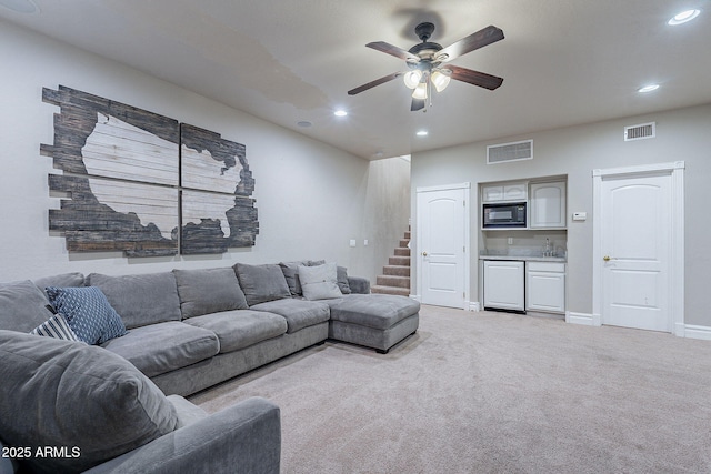 living room with ceiling fan and light colored carpet