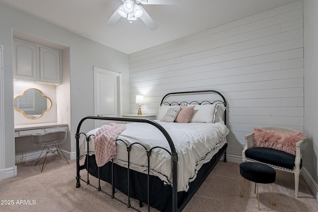 bedroom with ceiling fan, light colored carpet, and wooden walls