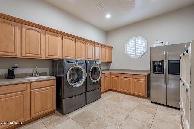 laundry room featuring cabinets, light tile patterned floors, washing machine and dryer, and sink