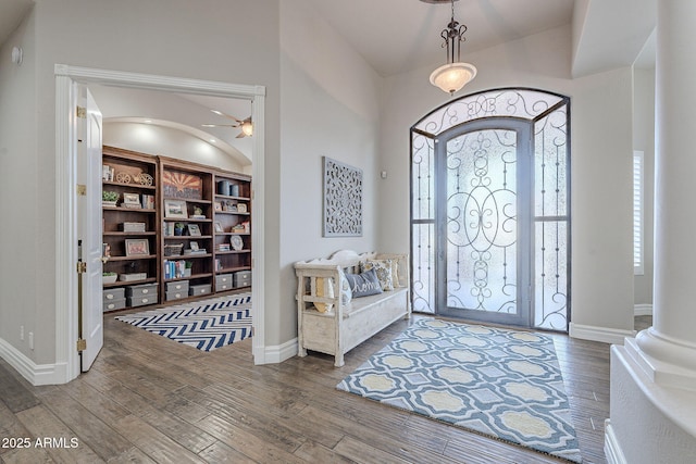 entryway with ceiling fan, wood-type flooring, and ornate columns