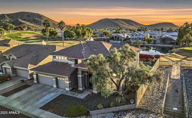 aerial view at dusk with a water and mountain view and a residential view