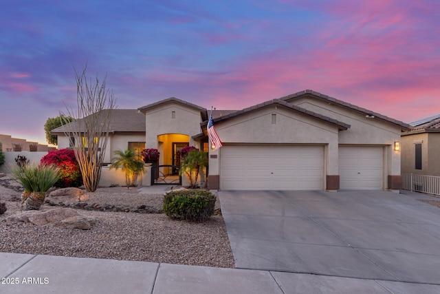 view of front of property with a garage, fence, concrete driveway, and stucco siding
