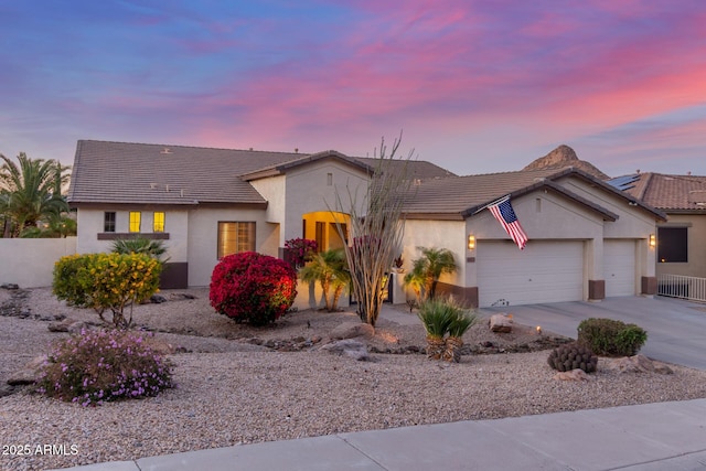 single story home featuring stucco siding, concrete driveway, a tile roof, and a garage
