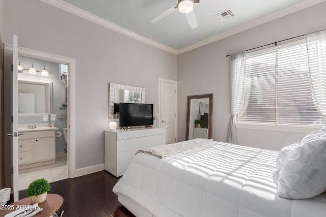 bedroom with wood finished floors, baseboards, visible vents, ensuite bathroom, and crown molding