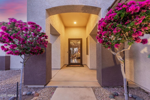 entrance to property featuring stucco siding