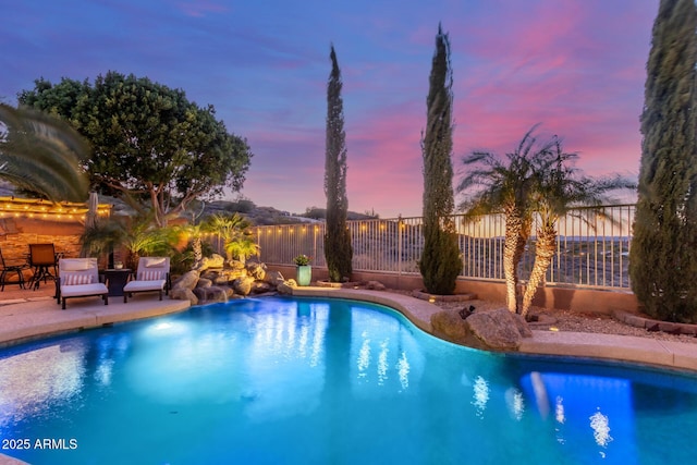 pool at dusk with a patio area, a fenced in pool, and fence
