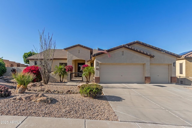 view of front of property with stucco siding, driveway, an attached garage, and fence