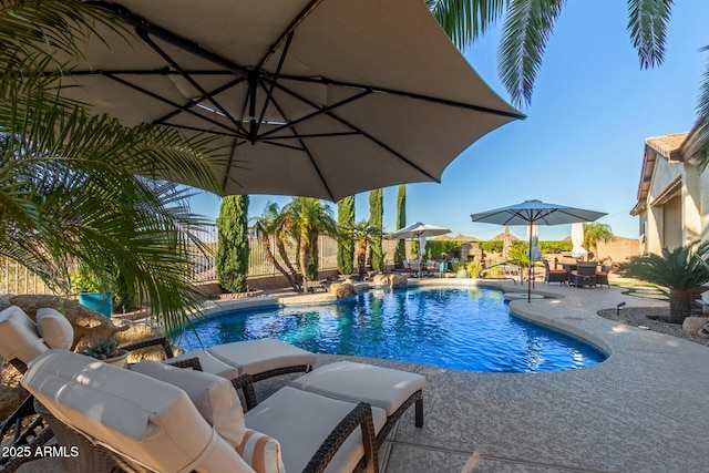 view of swimming pool with a patio area, a fenced in pool, and fence