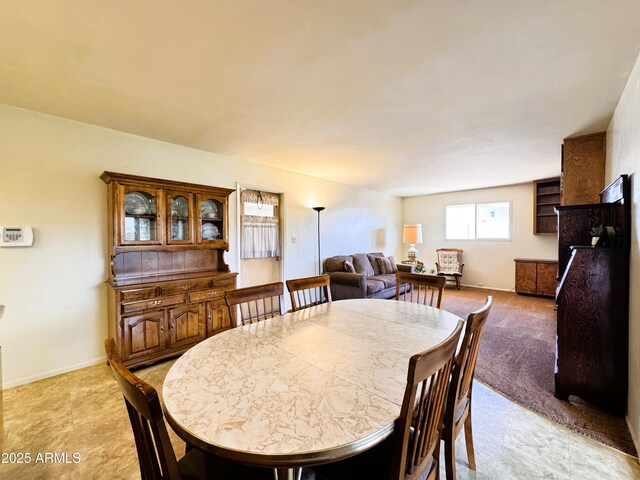 dining room with light colored carpet and baseboards