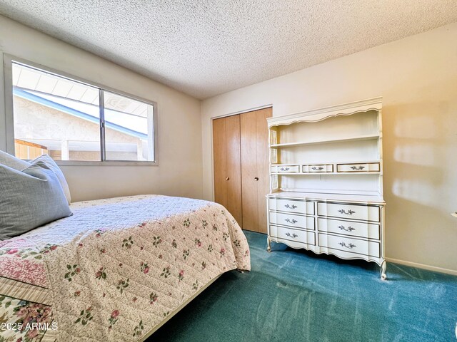 bedroom featuring dark carpet, a textured ceiling, and a closet