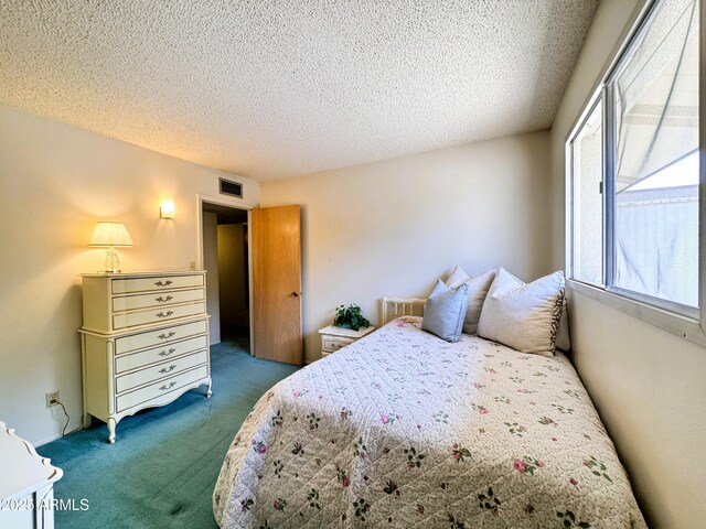 bedroom featuring a textured ceiling, visible vents, and carpet