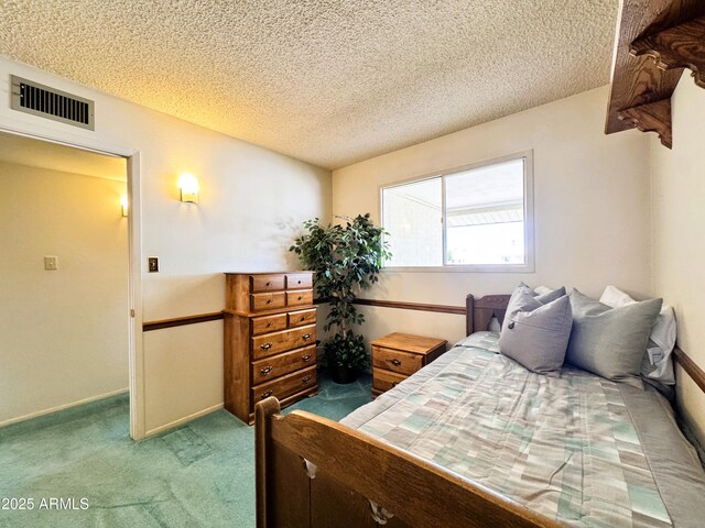 bedroom with carpet flooring, a textured ceiling, and visible vents