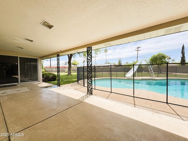 view of pool with fence, a water slide, a patio area, and a fenced in pool