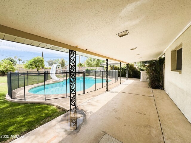 view of pool with a fenced in pool, a fenced backyard, a patio area, and a water slide