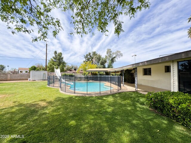 view of pool featuring fence, a fenced in pool, a patio area, an outdoor structure, and a yard