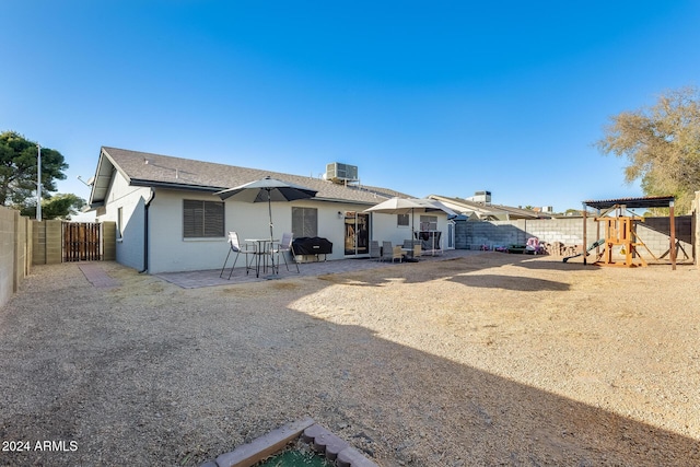 back of house with a playground, a patio area, and central AC