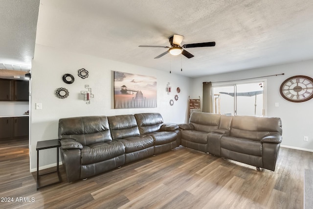 living room with ceiling fan, wood-type flooring, and a textured ceiling