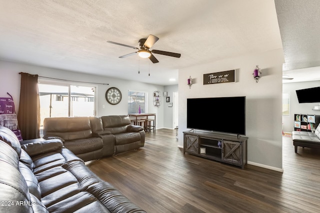 living room featuring a textured ceiling, ceiling fan, and dark wood-type flooring