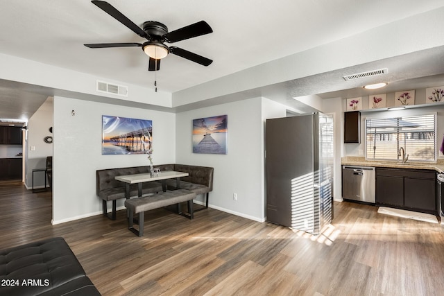 dining space featuring hardwood / wood-style floors, ceiling fan, and sink