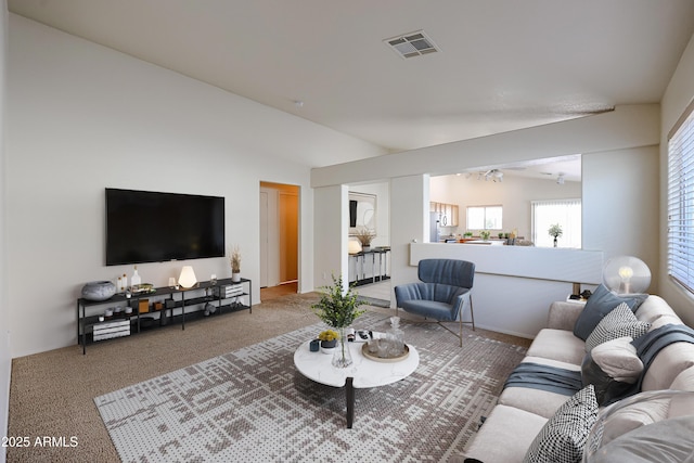 carpeted living area featuring visible vents and vaulted ceiling