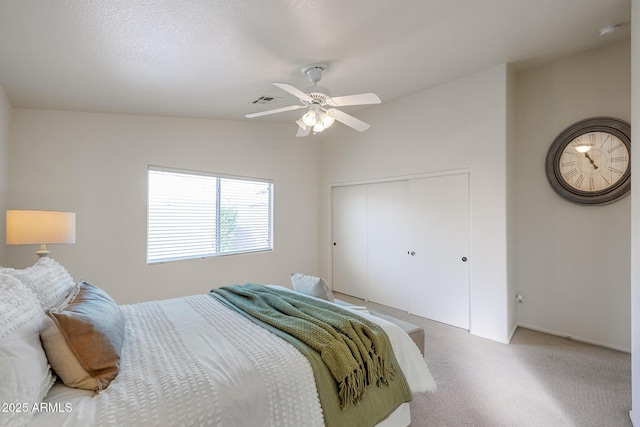 bedroom featuring visible vents, a ceiling fan, a textured ceiling, carpet floors, and a closet