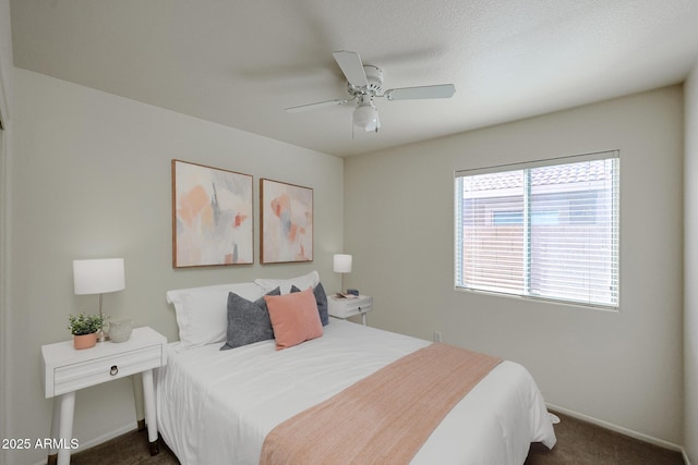 bedroom featuring ceiling fan, dark carpet, and baseboards