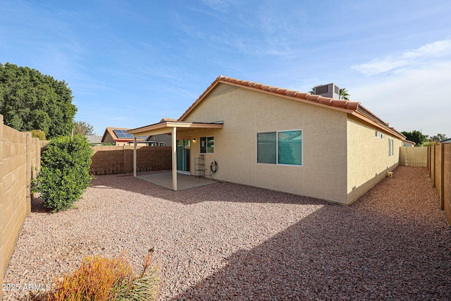 back of property with a patio, cooling unit, a fenced backyard, a tiled roof, and stucco siding