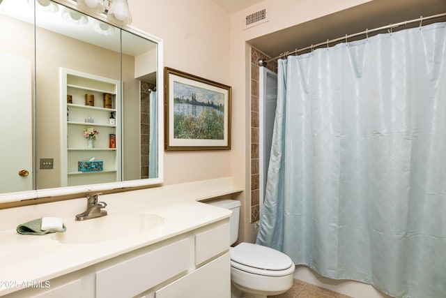 bathroom with toilet, vanity, and visible vents