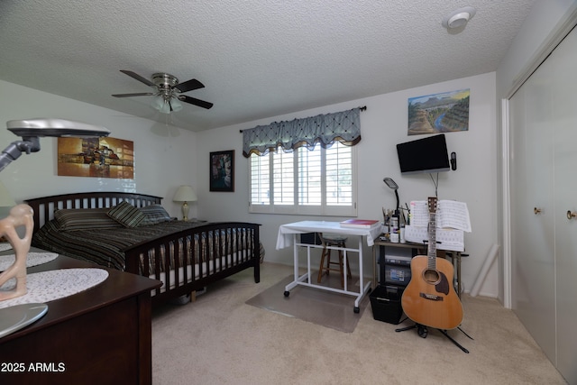 carpeted bedroom with a closet, a ceiling fan, and a textured ceiling