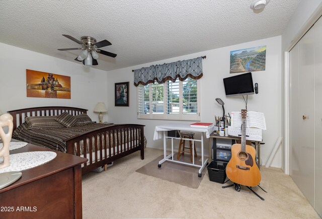 carpeted bedroom featuring ceiling fan, a closet, and a textured ceiling