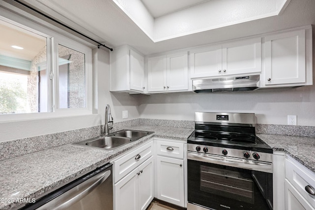 kitchen with white cabinets, stainless steel appliances, light stone counters, and sink