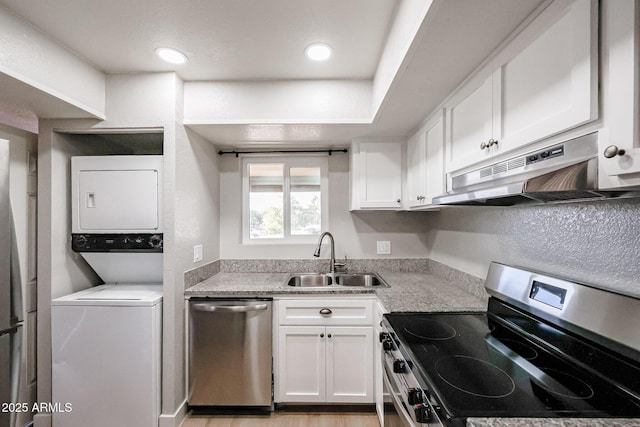 kitchen with stacked washer and clothes dryer, white cabinets, sink, light stone countertops, and stainless steel appliances