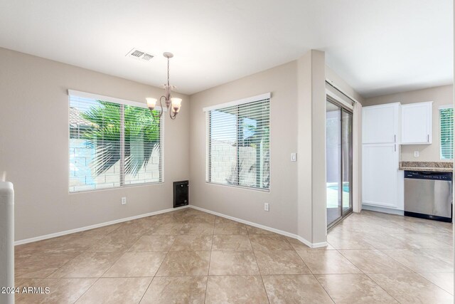 unfurnished dining area featuring a chandelier and light tile patterned flooring