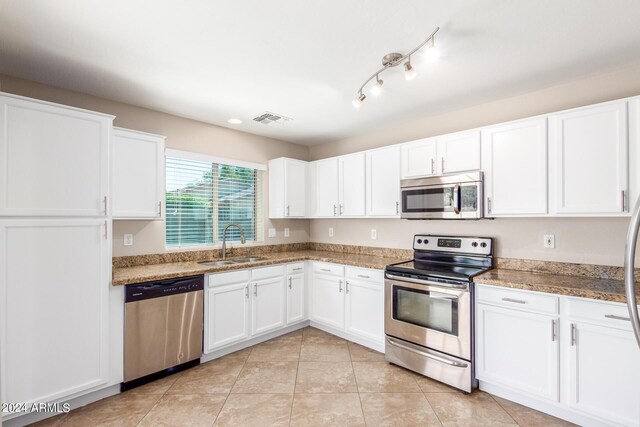 kitchen with white cabinetry, appliances with stainless steel finishes, light tile patterned floors, and sink