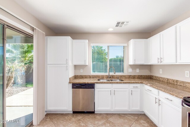 kitchen featuring light stone countertops, white cabinetry, sink, and stainless steel dishwasher