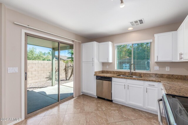 kitchen featuring appliances with stainless steel finishes, white cabinets, sink, and plenty of natural light