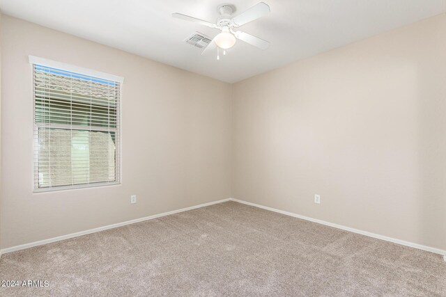 carpeted spare room with ceiling fan