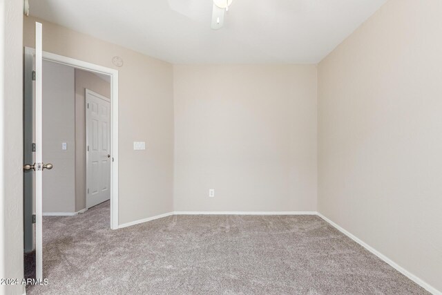 spare room featuring light carpet and ceiling fan