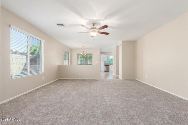 carpeted empty room with a wealth of natural light and ceiling fan