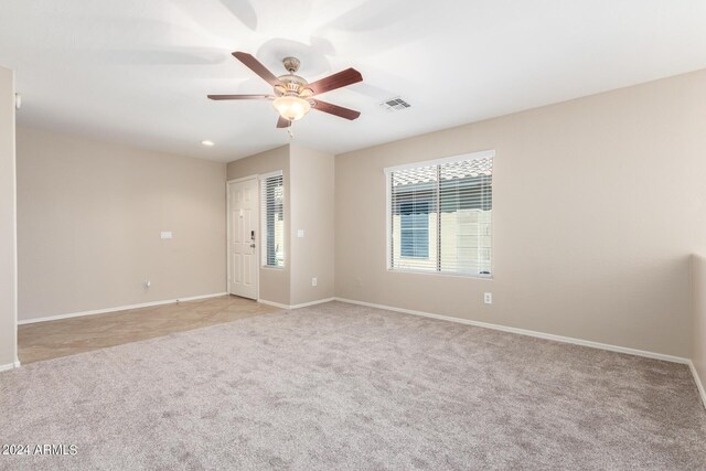 empty room featuring ceiling fan and light colored carpet