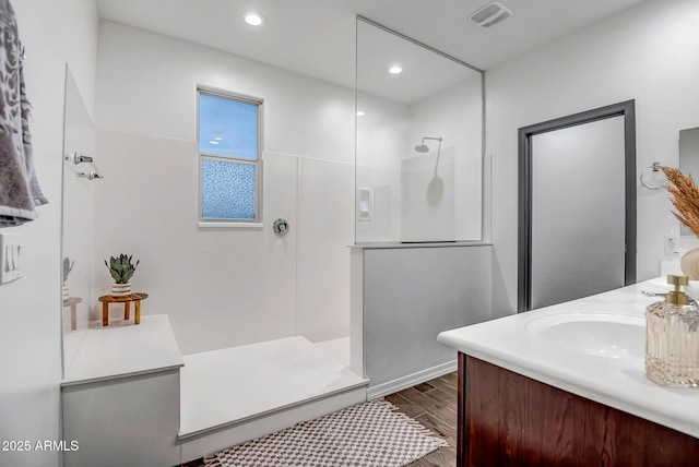 bathroom with vanity, hardwood / wood-style flooring, and a shower