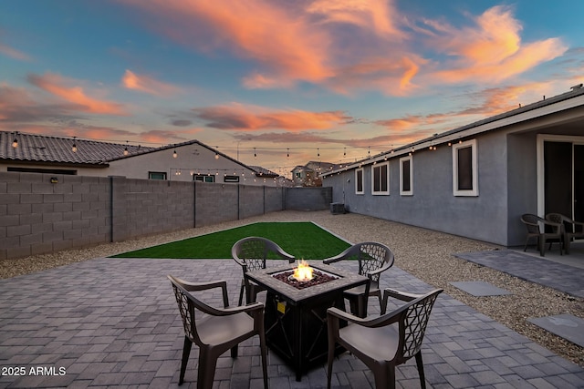 patio terrace at dusk featuring a fire pit