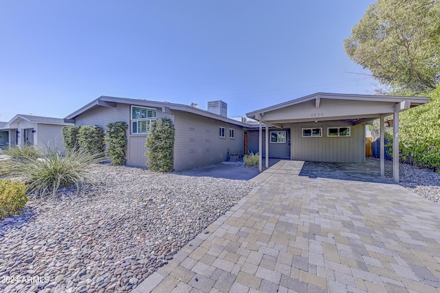 single story home featuring central AC and a carport