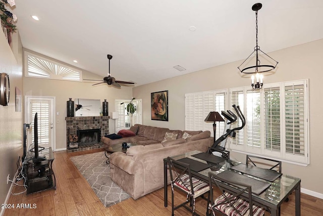 living room with hardwood / wood-style flooring, lofted ceiling, a wealth of natural light, and a fireplace